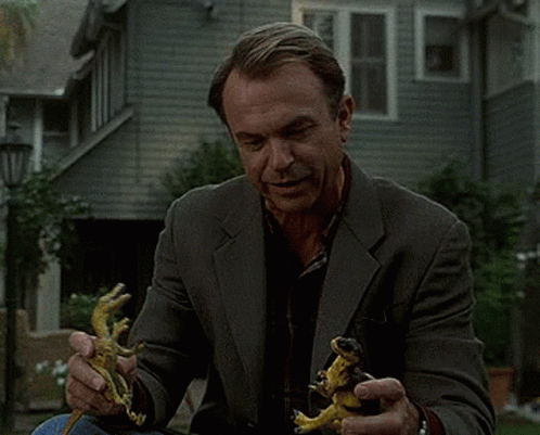 Man In Suit Holding Two Lizards GIF