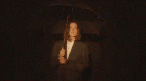 Man In Suit Holding Umbrella In Rain GIF