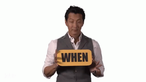 Man In Suit Holding When Sign GIF