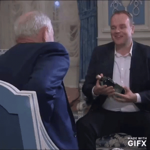 Man in Suit Holding Wine Bottle Talking to Another Man in Suit