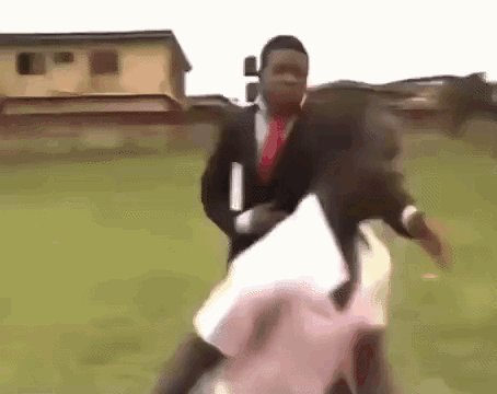 Man in Suit Holding Woman in Field