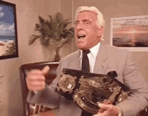 Man in Suit Holding Wrestling Belt