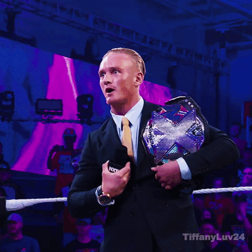 Man in Suit Holding WWE Championship Belt