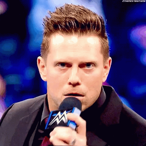 Man in Suit Holding WWE Microphone