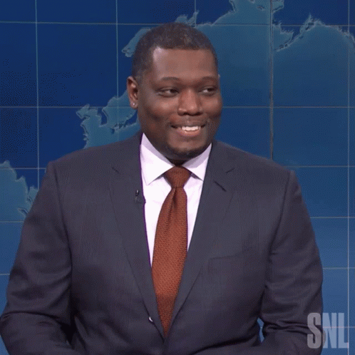 Man in Suit Holding Yellow Pencil with SNL Logo
