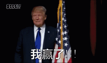 Man in Suit in Front of American Flag With Chinese Writing