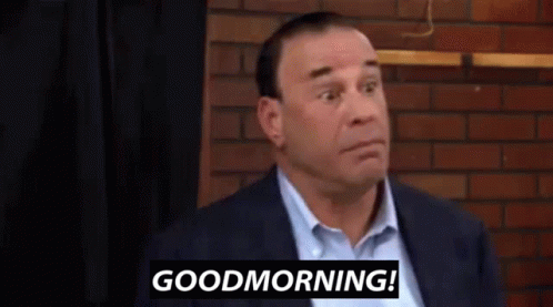 Man in Suit in Front of Brick Wall Says Good Morning