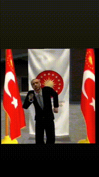 Man in Suit in Front of Flag Letter C