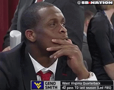 Man in Suit in Front of Geno Smith Sign