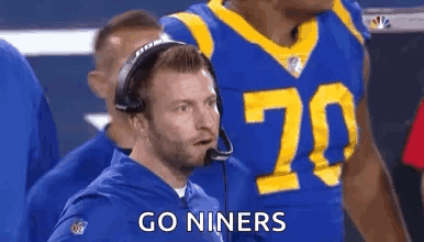 Man in Suit in Front of Los Angeles Rams Logo