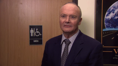 Man in Suit in Front of Men's Restroom