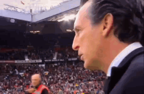Man in Suit in Front of Soccer Crowd