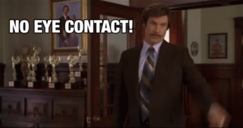 Man In Suit In Front Of Trophies Saying No Eye Contact GIF