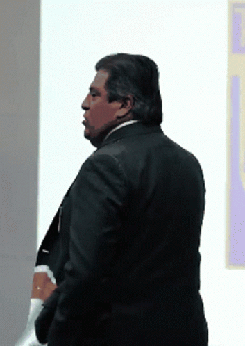 Man In Suit In Front Of Wall GIF