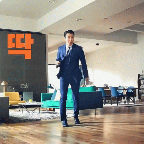 Man In Suit In Living Room With Couch GIF
