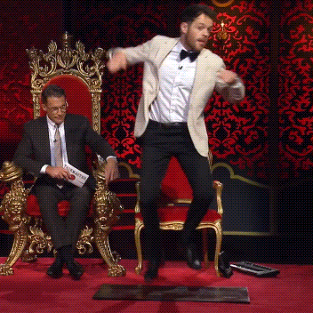 Man in Suit Jumping While Another Sits on Throne