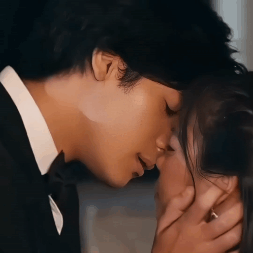 Man in Suit Kissing Woman on Forehead
