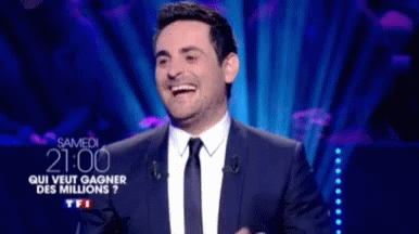 Man in Suit Laughing at Screen