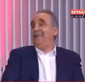 Man In Suit Laughing By Striped Wall GIF
