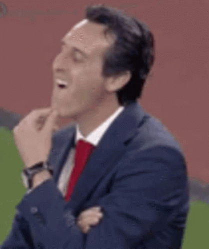 Man in Suit Laughing on Soccer Field