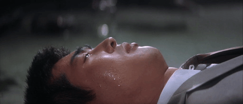 Man in Suit Laying Down With Sweat on Face