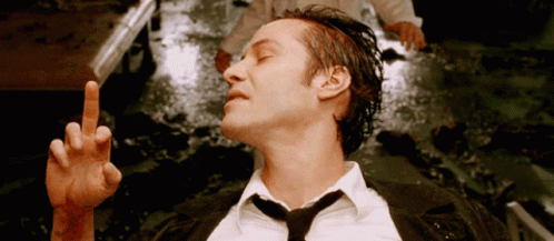 Man in Suit Laying in Water Giving Middle Finger