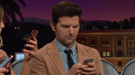 Man in Suit Looking at Cell Phone