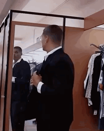 Man in Suit Looking at Himself in Mirror