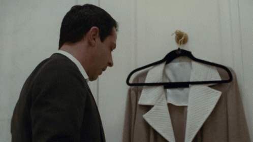Man In Suit Looking At Jacket On Hanger GIF
