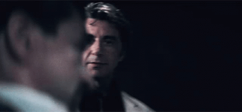 Man in Suit Looking at Man in Dark Room