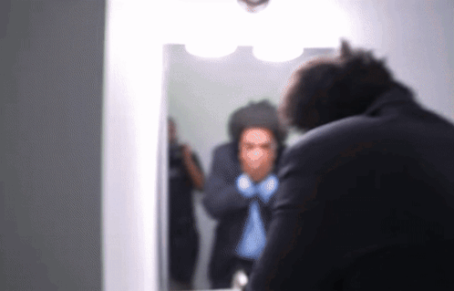 Man in Suit Looking at Mirror