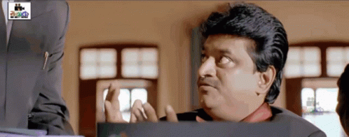 Man In Suit Making Funny Face At Cinema Sign GIF