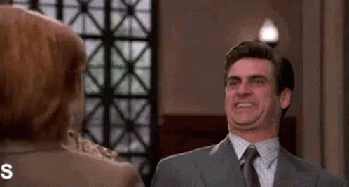 Man In Suit Making Funny Face At Woman GIF