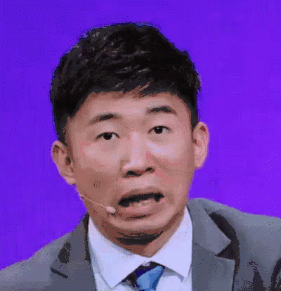 Man In Suit Making Funny Face With Microphone GIF