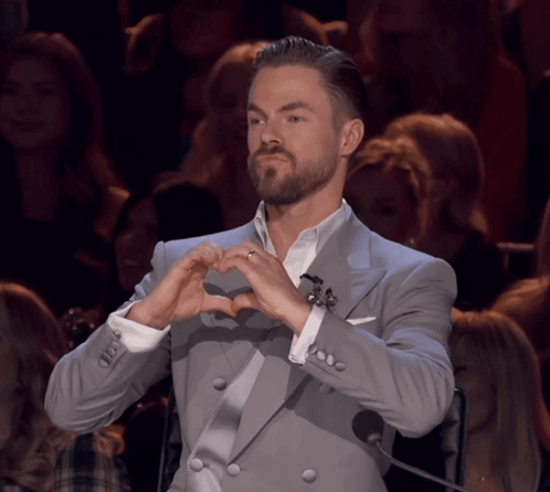 Man in Suit Making Heart With Hands