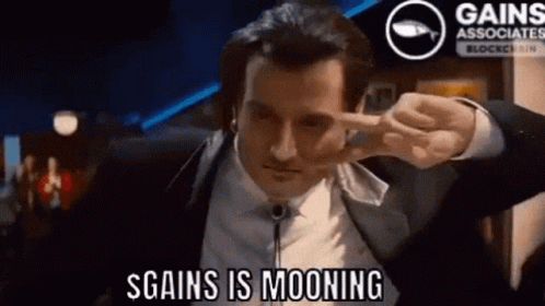 Man In Suit Making Peace Sign Saying S Gains Is Mooning GIF