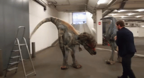 Man In Suit Next To Dinosaur GIF