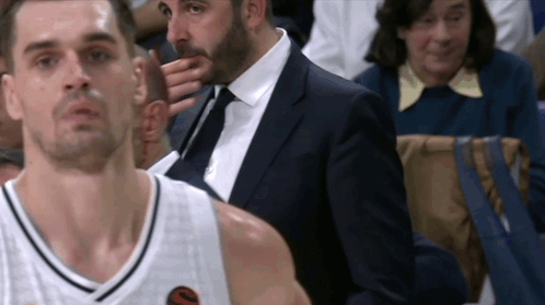 Man in Suit Next to Man in Basketball Uniform