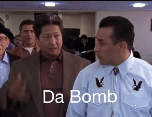 Man in Suit Next to Man in Blue Shirt Saying Da Bomb