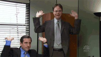 Man in Suit Next to Man With Arms Raised