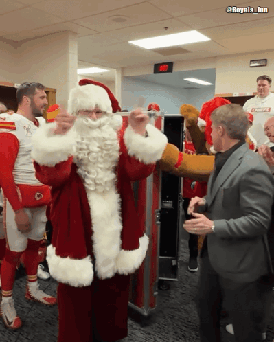Man In Suit Next To Santa Claus Costume GIF