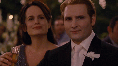 Man in Suit Next to Woman Holding Glass