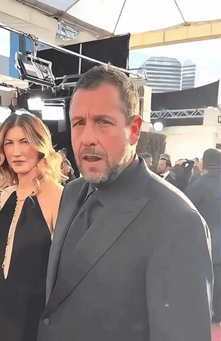 Man in Suit Next to Woman in Black Dress
