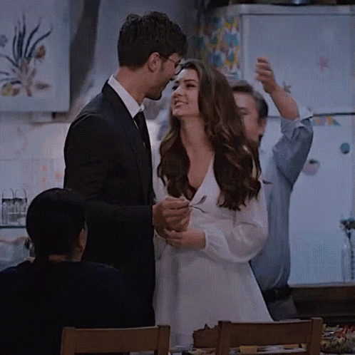 Man in Suit Next to Woman in White Dress Holding Spoon