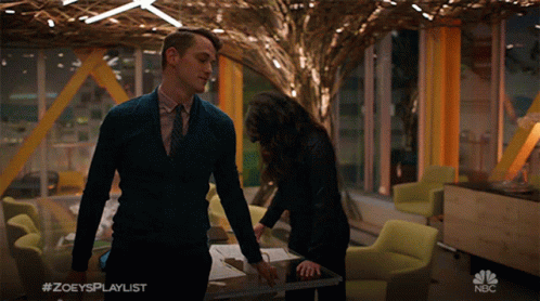 Man in Suit Next to Woman With Hashtag Zoey's Playlist