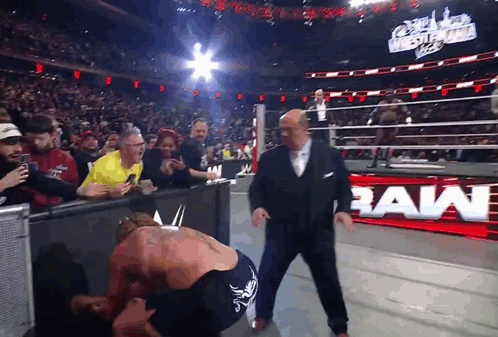 Man in Suit Next to Wrestler with Raw Sign
