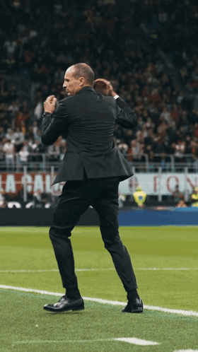 Man in Suit on Soccer Field With La Calcio Sign