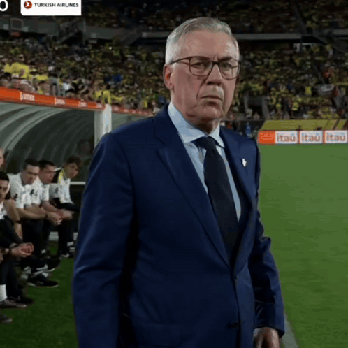 Man In Suit On Soccer Field With Turkish Airlines Ad GIF