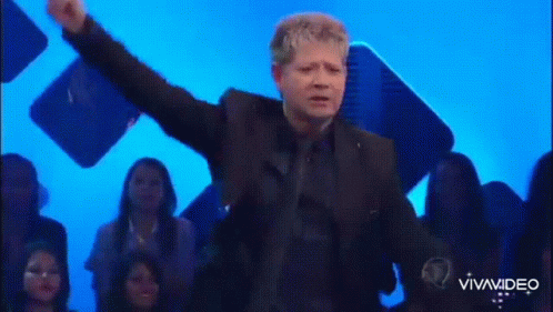 Man in Suit on Stage Arms Outstretched