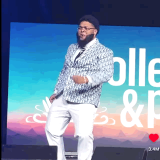 Man In Suit On Stage With Screen Saying Colle & P GIF